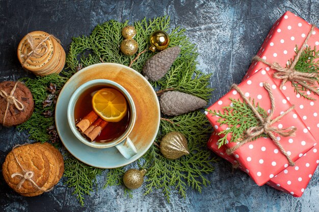 Vista superior deliciosas galletas con taza de té y regalos.