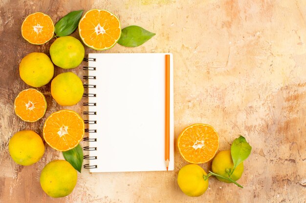 Vista superior deliciosas mandarinas frescas con bloc de notas