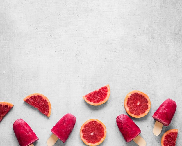 Vista superior de deliciosas paletas heladas con pomelo rojo y espacio de copia