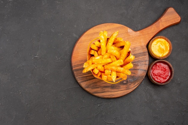 Vista superior deliciosas papas fritas dentro de la canasta sobre fondo oscuro snack burger comida rápida papa comida