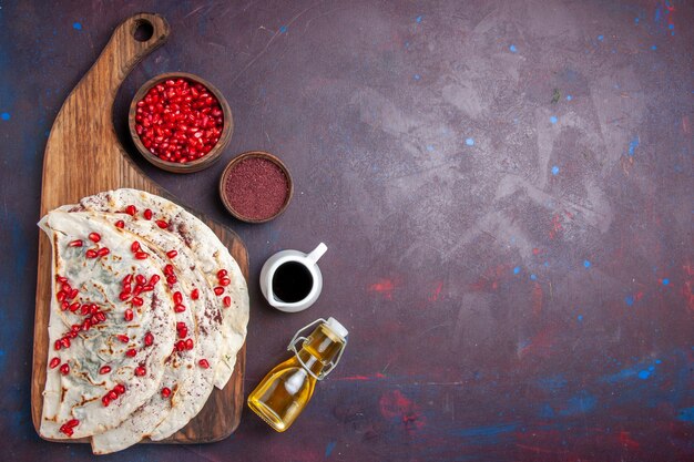Vista superior de deliciosas pitas de carne qutabs con granadas rojas frescas en un escritorio oscuro masa comida comida pita