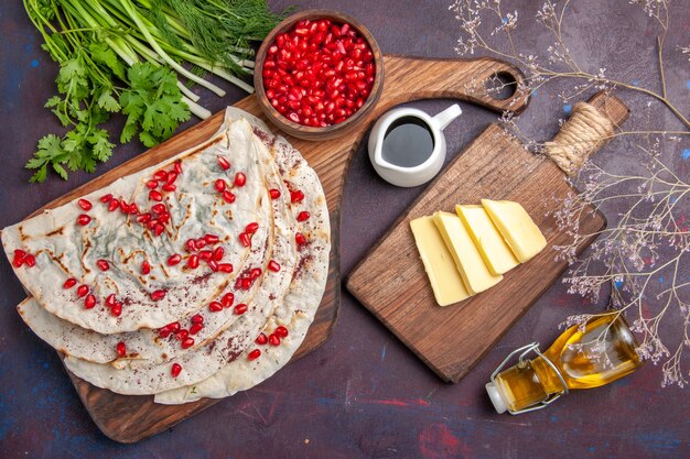 Vista superior deliciosas pitas de qutabs de carne con granadas rojas frescas en la superficie oscura comida de comida de carne de pita de masa