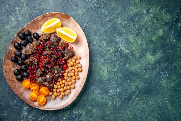 Vista superior deliciosas rebanadas de carne fritas con frijoles uvas y rodajas de limón dentro de la placa, plato comida comida fruta carne