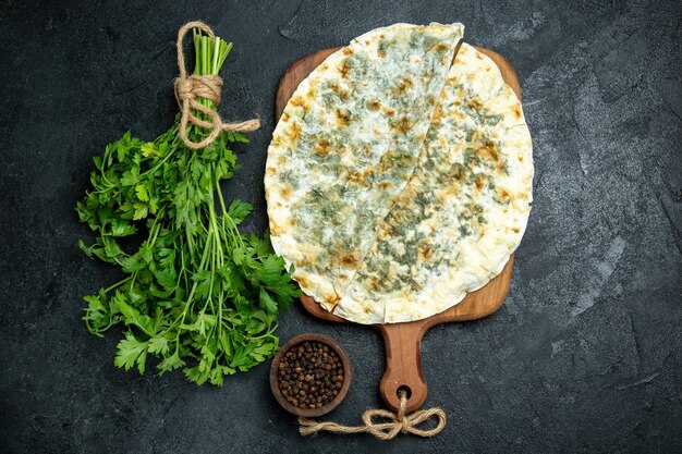 Vista superior deliciosas rebanadas de masa cocida de qutabs con verduras dentro en el espacio gris