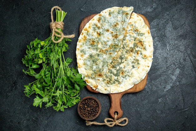 Vista superior deliciosas rebanadas de masa cocida de qutabs con verduras dentro en el espacio gris