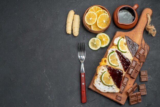 Vista superior de deliciosas rebanadas de pastel con chocolate en superficie oscura