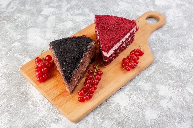 Foto gratuita vista superior de deliciosas rebanadas de pastel con crema de chocolate y frutas en el escritorio de madera con té dulce de azúcar de galleta de pastel de arándanos