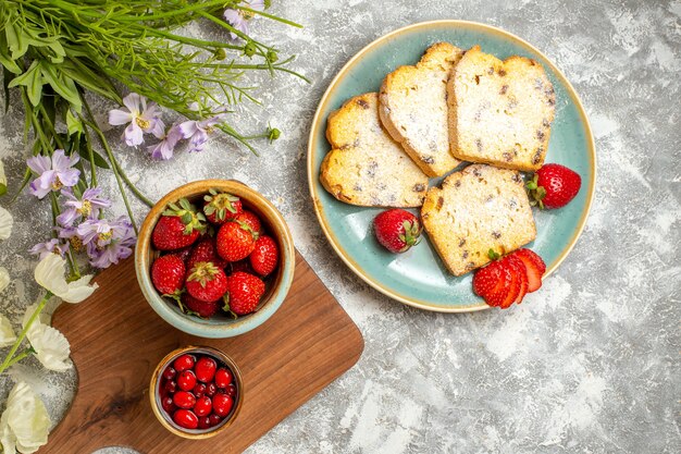 Vista superior de deliciosas rebanadas de pastel con fresas a la luz