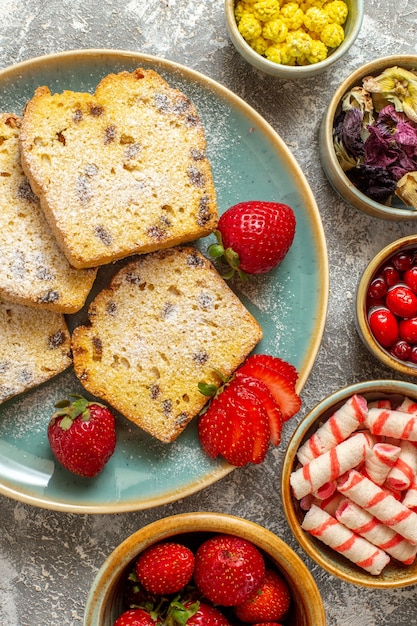 Vista superior de deliciosas rebanadas de pastel con frutas en superficie clara pastel dulce pastel de frutas