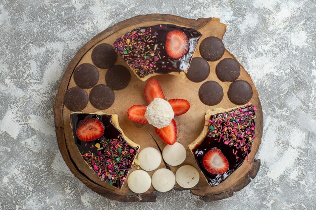 Vista superior de deliciosas rebanadas de pastel con galletas choco sobre superficie blanca