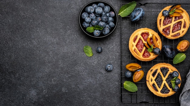 Vista superior de deliciosas tartas con ciruelas y espacio de copia