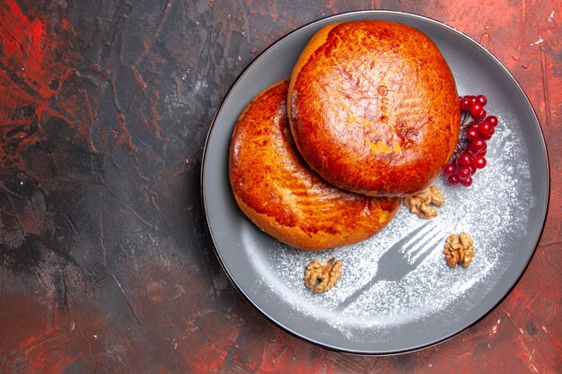 Vista superior deliciosas tartas con frutos rojos en mesa oscura tartas de pastelería dulce pastel