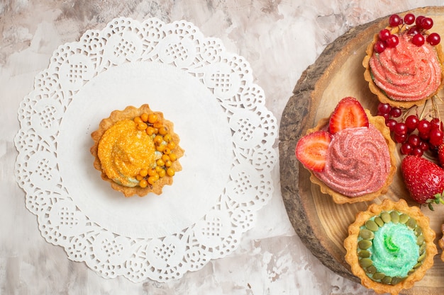 Vista superior deliciosas tortas de crema con frutas en mesa de luz postre galletas tortas dulces