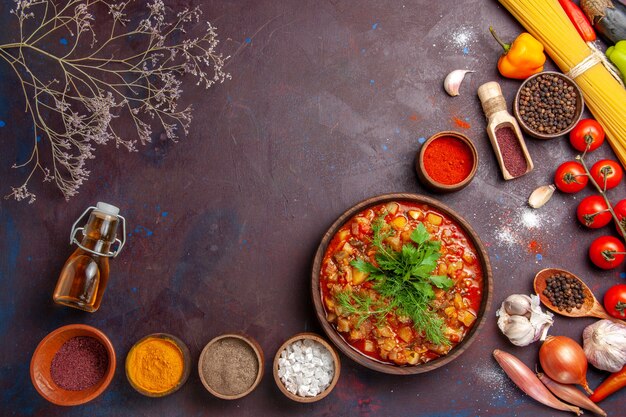 Vista superior deliciosas verduras cocidas en rodajas con diferentes condimentos en salsa de comida de comida de sopa de escritorio oscuro