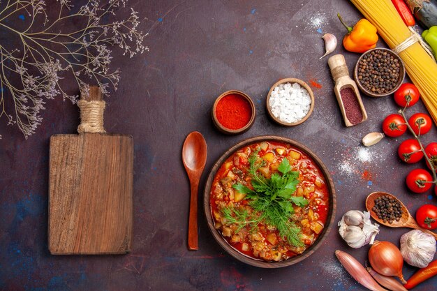 Vista superior deliciosas verduras cocidas en rodajas con verduras y condimentos en la salsa de comida de comida de sopa de fondo oscuro