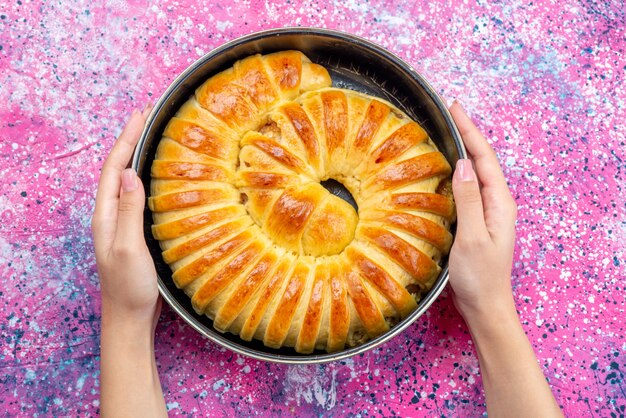 Vista superior del delicioso brazalete de pastelería horneada formado dentro de la bandeja en el escritorio brillante, masa de galleta de galleta de pastelería azúcar dulce