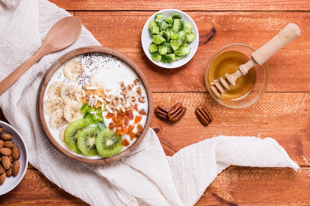 Foto gratuita vista superior delicioso desayuno tazón con kiwi y yogurt