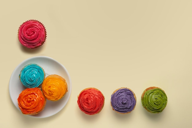 Vista superior delicioso glaseado de cupcake arco iris bodegón