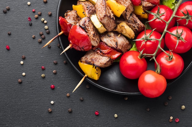 Vista superior del delicioso kebab con tomates en placa