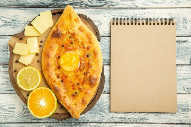 Vista superior delicioso pan de huevo al horno con queso en escritorio rústico