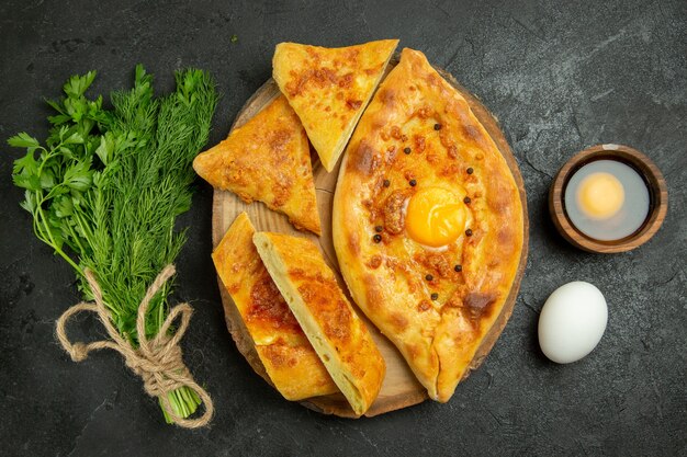 Vista superior del delicioso pan de huevo al horno con verduras en un espacio gris