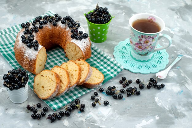 Una vista superior delicioso pastel con arándanos frescos y té en el escritorio blanco pastel galleta té baya