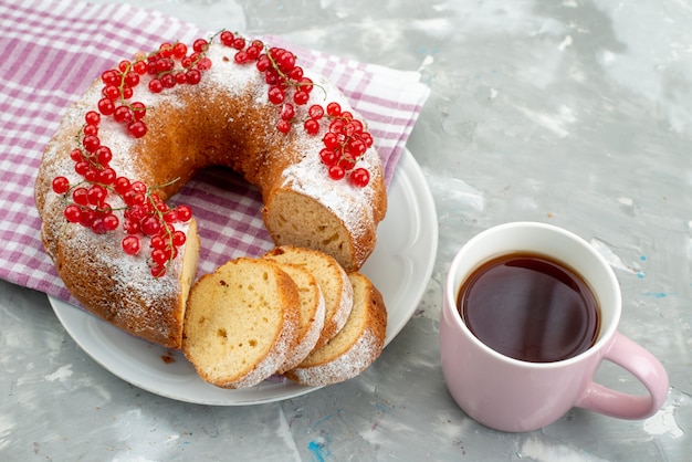 Una vista superior del delicioso pastel con arándanos rojos frescos, canela y té en el escritorio blanco, pastel, galleta, té, baya
