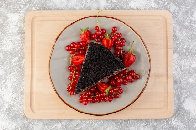 Foto gratuita vista superior delicioso pastel de chocolate en rodajas con crema de choco y arándanos rojos frescos en el escritorio de madera pastel de masa de galletas hornear dulce