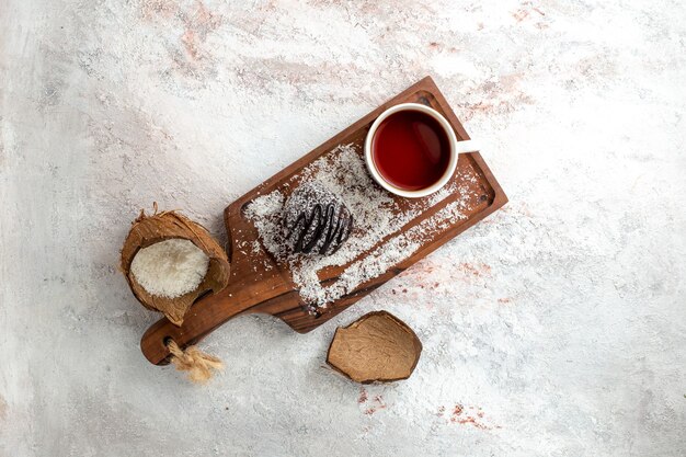 Vista superior delicioso pastel de chocolate con una taza de té en el escritorio blanco claro pastel de chocolate galleta azúcar dulce té de galleta