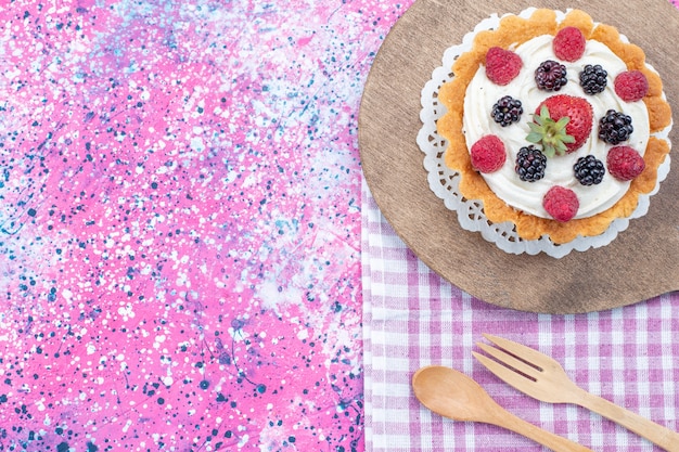 Vista superior del delicioso pastel con crema y bayas frescas en un escritorio ligero, bizcocho de baya