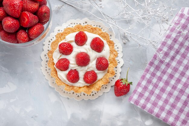 Vista superior del delicioso pastel con crema y fresas rojas frescas en la mesa de luz pastel crema de galletas de frutas