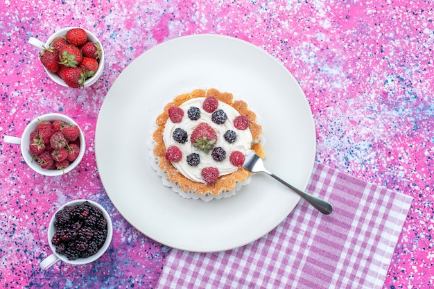 Foto gratuita vista superior del delicioso pastel cremoso con diferentes bayas frescas en un escritorio de luz brillante, fruta de baya agria fresca