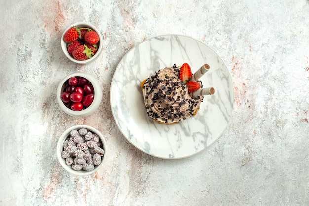 Vista superior delicioso pastel cremoso con frutas frescas en la superficie blanca pastel de té de cumpleaños galleta crema dulce