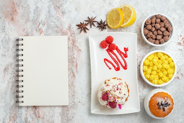 Foto gratuita vista superior delicioso pastel cremoso con limón y caramelos sobre fondo blanco pastel de crema de galletas té dulces