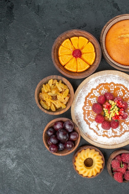 Foto gratuita vista superior delicioso pastel de frambuesa con frutas y pasas sobre fondo gris pastel dulce fruta baya pastel galleta