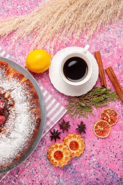 Vista superior del delicioso pastel de fresa azúcar en polvo con galletas y té en la superficie rosada pastel dulce azúcar galleta té