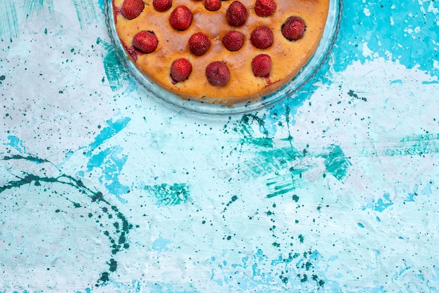 Vista superior del delicioso pastel de fresa en forma redonda con frutas en la parte superior en azul brillante, masa de pastel, baya de fruta de galleta dulce