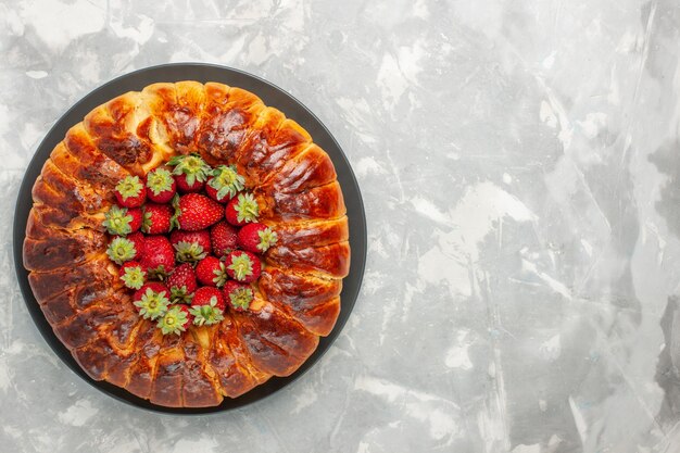 Vista superior del delicioso pastel de fresa con fresas rojas frescas sobre superficie blanca