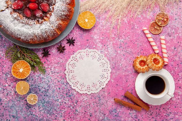 Vista superior delicioso pastel de fresa con galletas y té en pastel de escritorio rosa claro hornear pastel de galleta de galleta de azúcar dulce