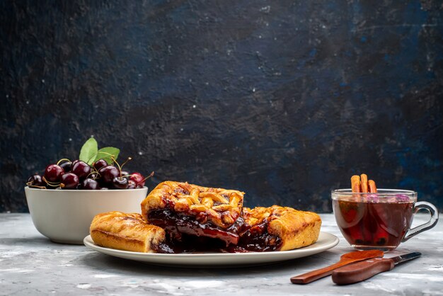 Una vista superior del delicioso pastel de fresa con gelatina de fresa, cerezas frescas y té en la mesa de luz, pastel, galleta, azúcar