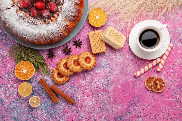 Vista superior delicioso pastel de fresa con té de galletas y gofres en el fondo rosa claro pastel hornear pastel de galleta de galleta de azúcar dulce
