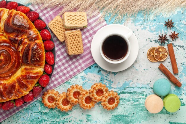 Vista superior delicioso pastel con galletas de fresas rojas y waffles en superficie azul