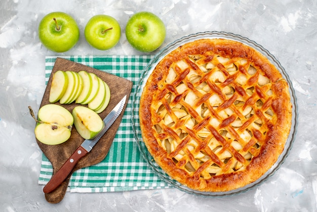Una vista superior delicioso pastel de manzana con manzanas verdes frescas en el escritorio gris pastel galleta azúcar fruta hornear