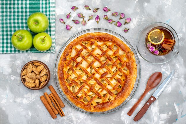 Una vista superior del delicioso pastel de manzana con té de manzanas verdes frescas y pastel de canela, galleta, azúcar, fruta