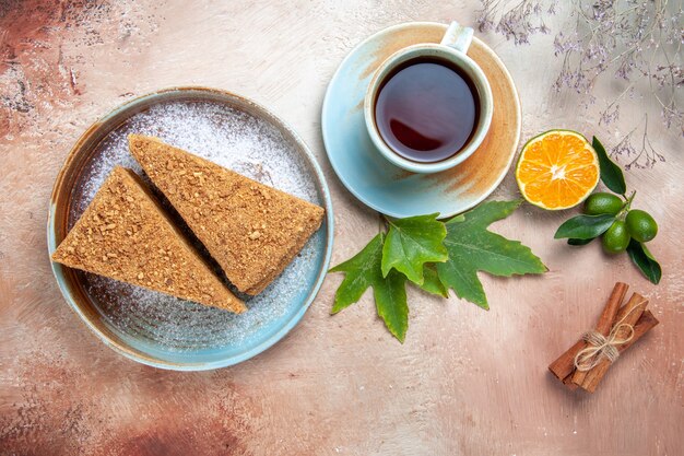 Vista superior del delicioso pastel de miel con una taza de té en la mesa de luz pastel pastel galleta dulce