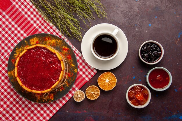 Vista superior del delicioso pastel de postre con taza de café y mermeladas de frutas en la superficie oscura galleta de azúcar postre dulce pastel