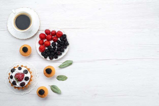 Vista superior del delicioso pastelito con crema y galletas de bayas en el escritorio blanco, pastel de galletas hornear frutas baya