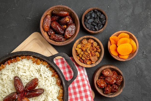 Vista superior delicioso plato de arroz cocido plov con diferentes pasas en el fondo oscuro plato de pasas comida arroz cena aceite