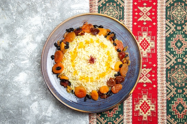 Foto gratuita vista superior delicioso plato de arroz cocido shakh plov con pasas dentro de la placa en el escritorio blanco