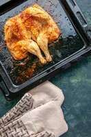 Foto gratuita vista superior delicioso pollo al horno con especias sobre una superficie azul oscuro pimiento picante plato de carne comida cena barbacoa pájaro